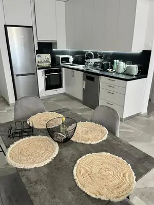 a kitchen with a table and some chairs and a counter at Lazuli Beachfront Sea View Ap 34 in Larnaka