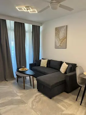 a living room with a couch and a table at Lazuli Beachfront Sea View Ap 34 in Larnaka