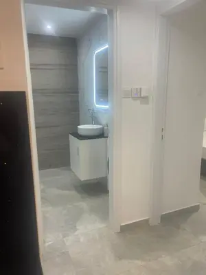 a white bathroom with a sink and a mirror at Lazuli Beachfront Sea View Ap 34 in Larnaka
