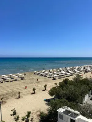 a beach with a lot of umbrellas and the ocean at Lazuli Beachfront Sea View Ap 34 in Larnaka