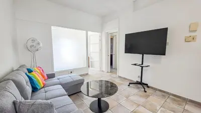 a living room with a couch and a flat screen tv at Citycenter Comfy Apartment in Larnaka