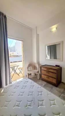 a bedroom with a bed and a dresser and a window at Citycenter Comfy Apartment in Larnaka