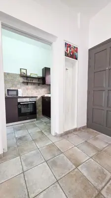 a kitchen with a door and a tile floor at Citycenter Comfy Apartment in Larnaka