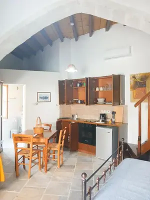 a kitchen with a table and chairs in a room at Traditional Cozy Retreat in Skarinou