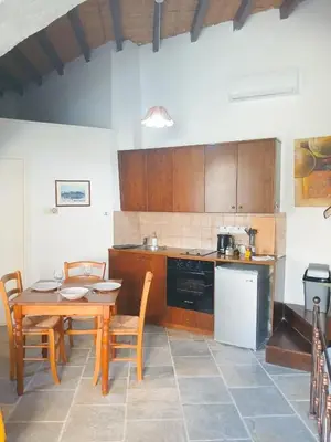 a kitchen with a wooden table and a table and chairs at Traditional Cozy Retreat in Skarinou
