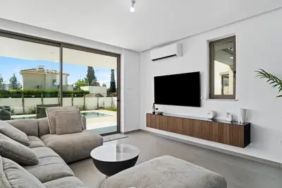 a living room with a couch and a tv at St Nicholas Luxury 3-Bed Villa in Paralimni