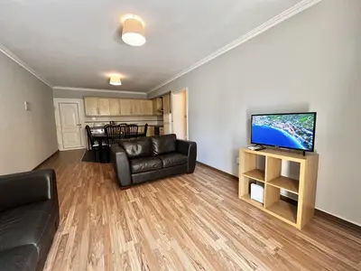 a living room with a couch and a flat screen tv at STAY Napa Oniro Apartment in Ayia Napa