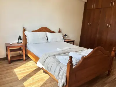 a bedroom with a bed with white sheets and a dresser at STAY Napa Oniro Apartment in Ayia Napa