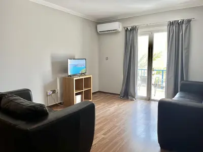 a living room with a couch and a television at STAY Napa Oniro Apartment in Ayia Napa