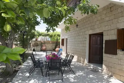 a table with chairs and flowers on a patio at Marianna Mansion in Pachna