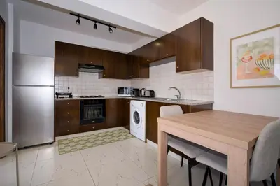 a kitchen with a table and a sink and a dishwasher at Cosy Charming Balcony Suite in Nicosia