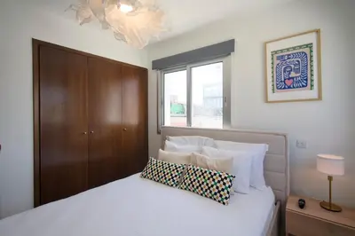 a bedroom with a white bed and a window at Cosy Charming Balcony Suite in Nicosia