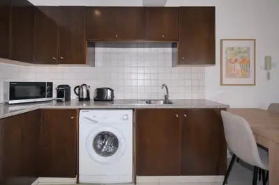 a kitchen with a washing machine and a sink at Cosy Charming Balcony Suite in Nicosia