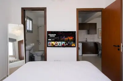a bedroom with a white bed and a bathroom at Cosy Charming Balcony Suite in Nicosia