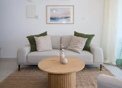 a living room with a couch and a wooden table at Cosy Charming Balcony Suite in Nicosia