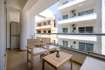a balcony with two chairs and a table at Giorgio Downtown 2 Bedroom Apartment in Larnaka