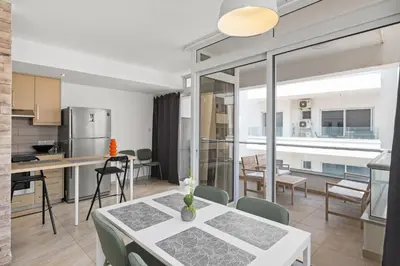 a kitchen and living room with a table and chairs at Giorgio Downtown 2 Bedroom Apartment in Larnaka