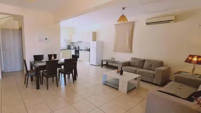 a living room with a couch and a table with chairs at STAY Sunny Bay Villa in Protaras