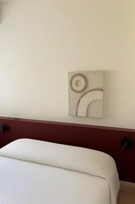 a bedroom with a white bed with a picture on the wall at Larnaca Seaview Apartment with pool & parking in Larnaka