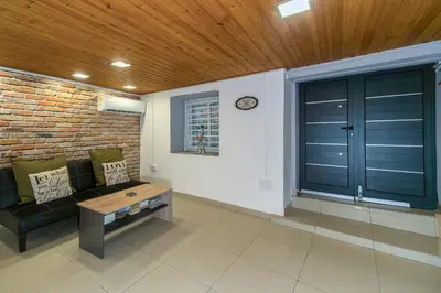 a living room with a black couch and a brick wall at City Centre Studio Eleftheria Sq in Nicosia