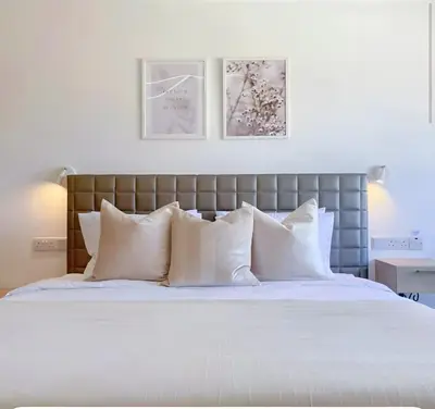 a bedroom with a large bed with white pillows at Plateia Suite Brillante in Nicosia