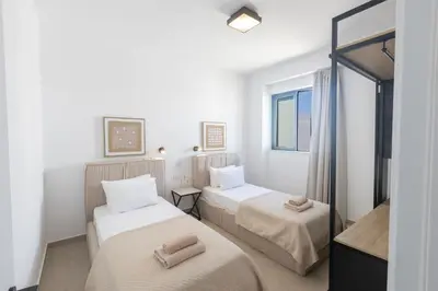 a hotel room with two beds and a window at Ayia Napa Orea Villa OR8 in Ayia Napa