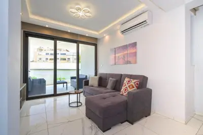 a living room with a couch and a large window at Luxury Modern Larnaca Central in Larnaka