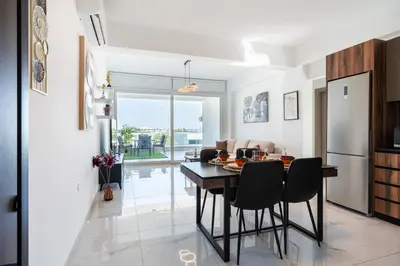 a kitchen and dining room with a table and chairs at Doria 2-Bedroom Apartment & Balcony in Larnaca in Aradhippou