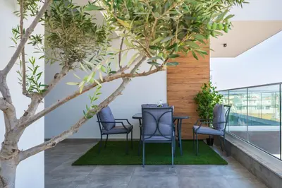 a tree in a room with chairs and a table at Doria 2-Bedroom Apartment & Balcony in Larnaca in Aradhippou