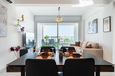 a living room with a dining room table with chairs at Doria 2-Bedroom Apartment & Balcony in Larnaca in Aradhippou