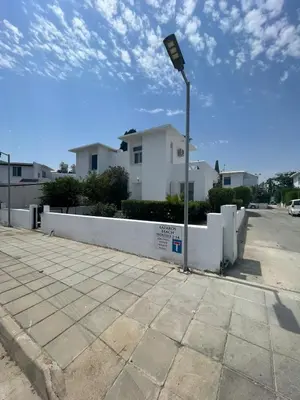 a street light in front of a white fence at Azure Waves House in Voroklini