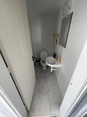 a white bathroom with a toilet and a sink at Azure Waves House in Voroklini