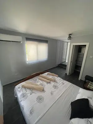 a bedroom with a white bed with a window at Azure Waves House in Voroklini