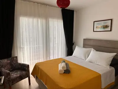 a bedroom with a bed and a chair and a window at Flat in Kyrenia, Cyprus in Kérynia