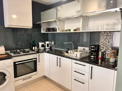 a kitchen with white cabinets and a sink and a dishwasher at Flat in Kyrenia, Cyprus in Kérynia