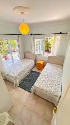 two beds in a room with two windows at Villa NATURA in Strovolos