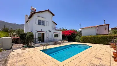 a villa with a swimming pool in front of a house at Villa NATURA in Strovolos