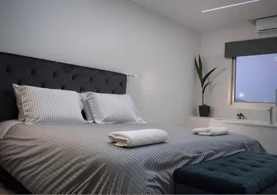 a bedroom with a large bed with two towels on it at Plateia Suite Deluxe in Nicosia