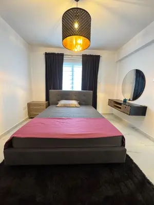 a bedroom with a large bed with a pink blanket at Bachelor Court 1 in Ayia Napa