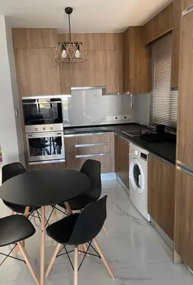 a kitchen with a table and chairs and a dishwasher at Bachelor Court 1 in Ayia Napa