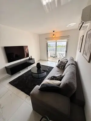 a living room with a couch and a flat screen tv at Bachelor Court 1 in Ayia Napa