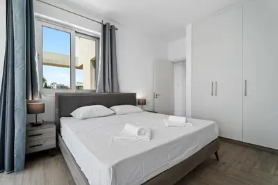 a bedroom with a large white bed with a window at Levanda Hills Haven in Protaras in Paralimni