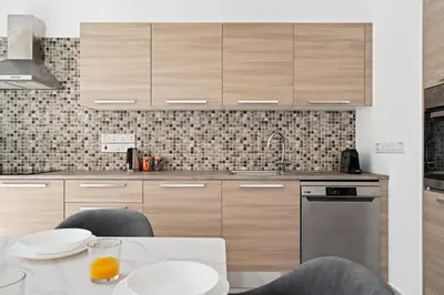 a kitchen with wooden cabinets and a table with chairs at Levanda Hills Haven in Protaras in Paralimni