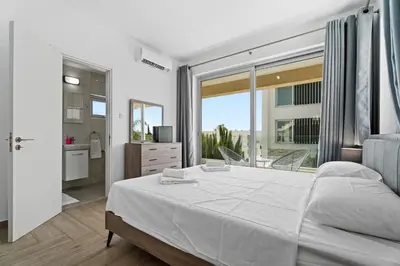 a bedroom with a large bed and a large window at Levanda Hills Haven in Protaras in Paralimni