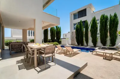 a patio of a house with a table and chairs at Levanda Hills Haven in Protaras in Paralimni