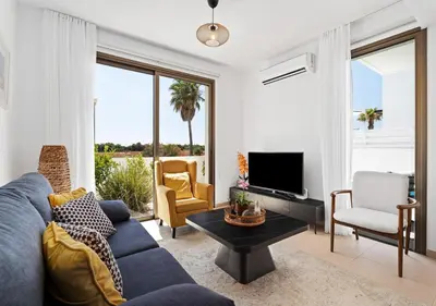 a living room with a blue couch and a tv at Levanda Dreams 8 in Paralimni
