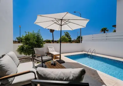 a patio with a pool and an umbrella and chairs at Levanda Dreams 8 in Paralimni