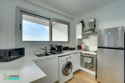 a kitchen with a refrigerator and a washer and dryer at The lighthouse 1 bedroom 604 in Larnaka