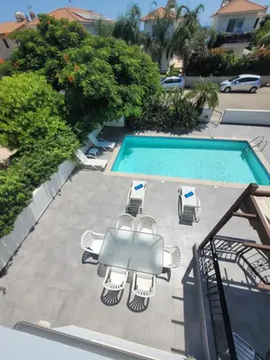a swimming pool with a table and chairs next to a pool at Ayia Napa Marina Luxury Villas - Aquamarine in Ayia Napa