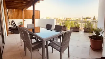 a patio with a table and chairs on a balcony at Oasis Penthouse Luxury Suite in Limassol